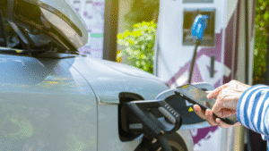 EV car charging with a person holding a phone looking at it