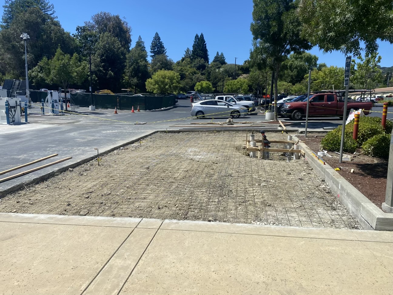 Construction site at a parking lot with cars in the background
