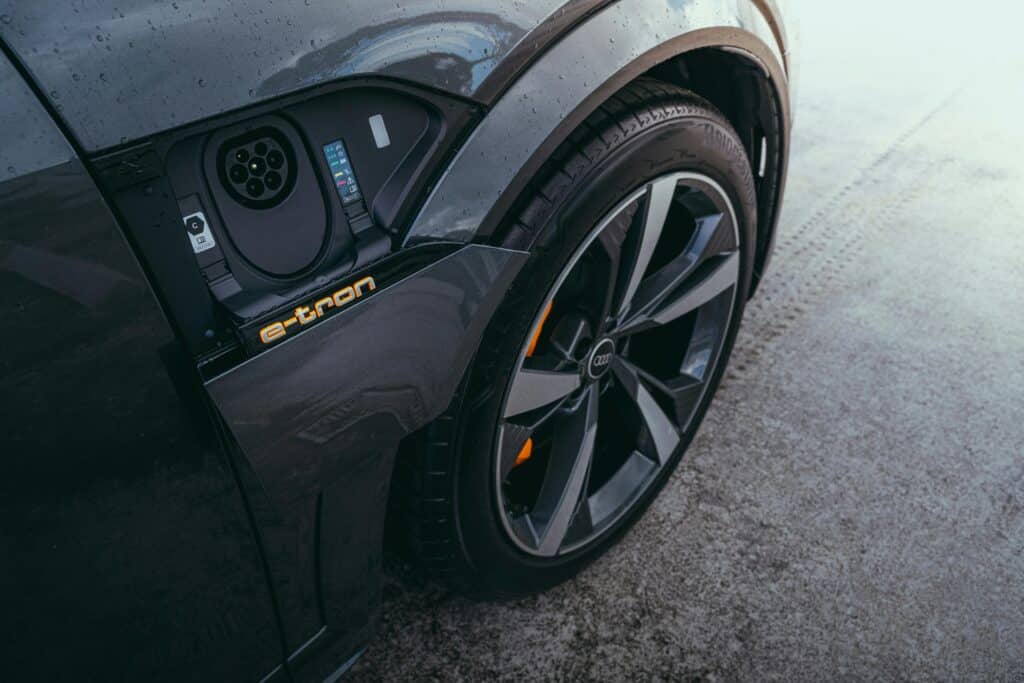 electric cars versus gas: close up of J1772 charger port on a black vehicle